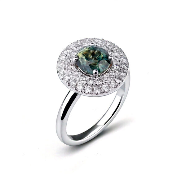 Bague en or blanc sertie d'un saphir vert entouré d’un double halo de diamants.